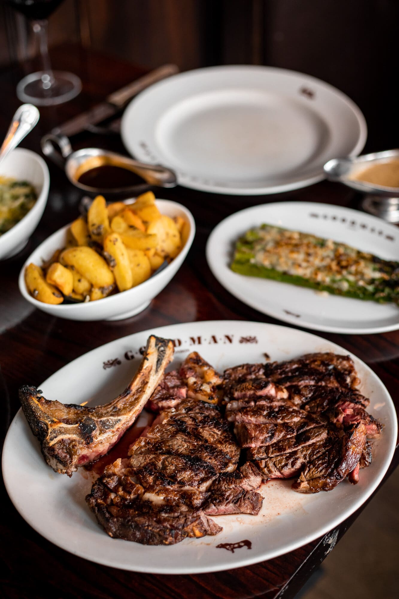 A picture of two steaks on a platter with chips and asparagus at Goodman steak house in Mayfair