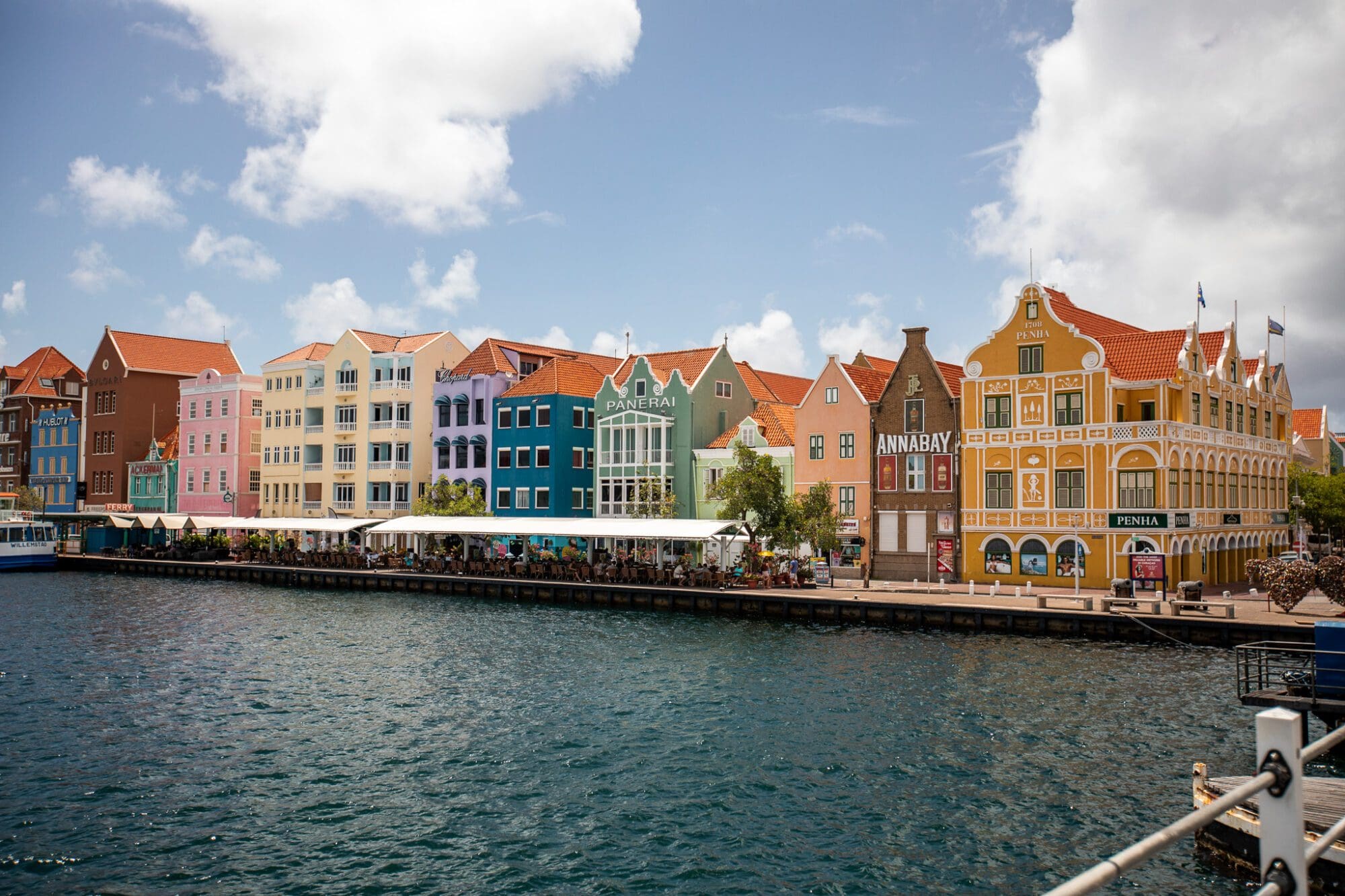 A line of multicoloured Dutch houses in front of a river in Willemstad, Curacao